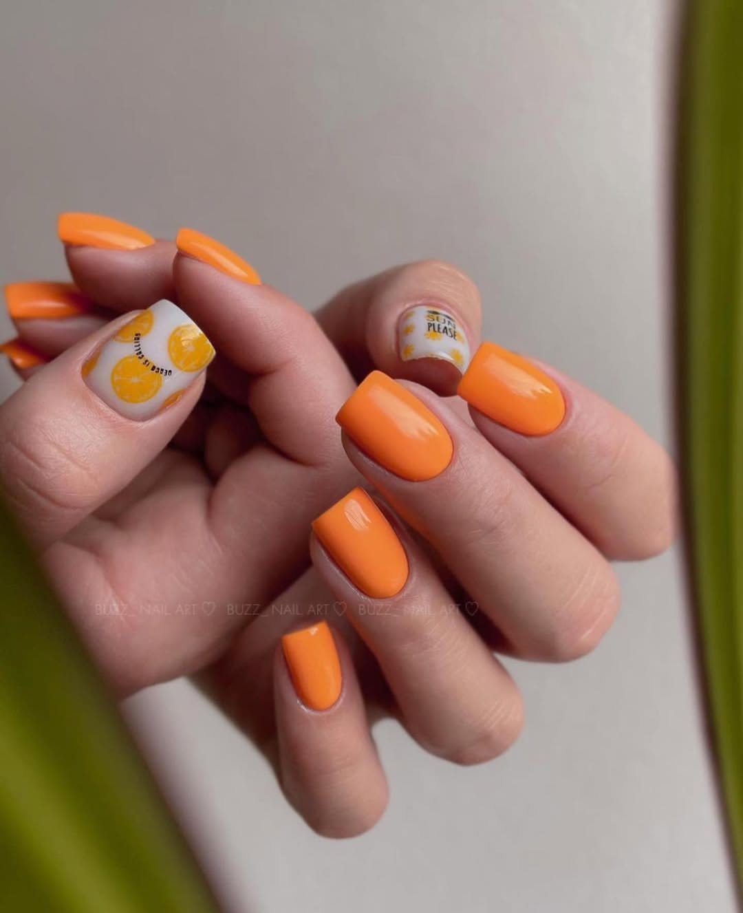 Vibrant orange nails with playful citrus design