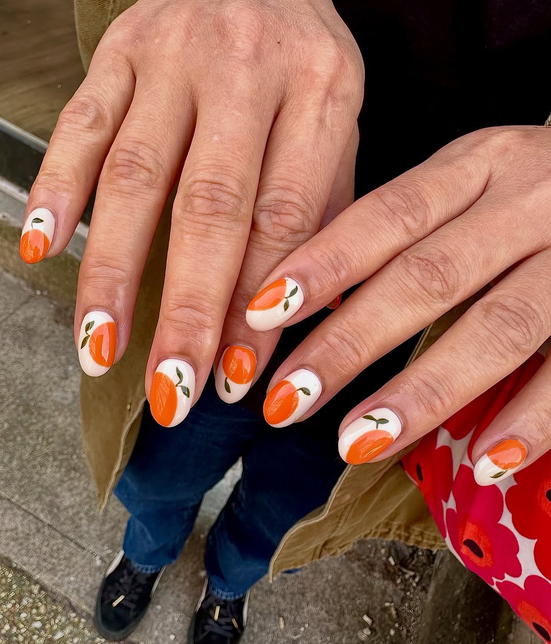 Vibrant Orange Nails with Cute Leaf Designs