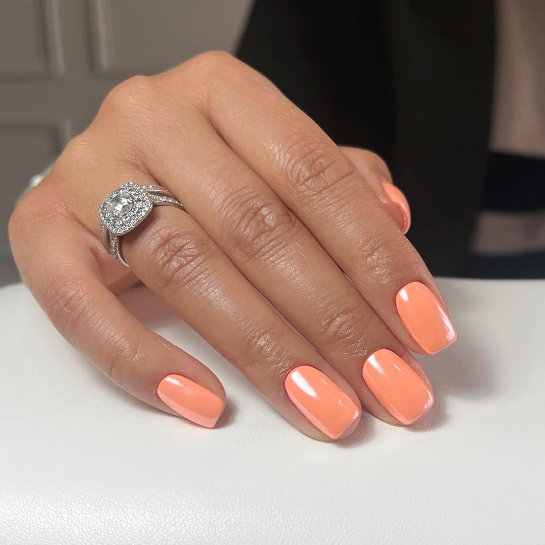 Vibrant orange nails for a summer glow.