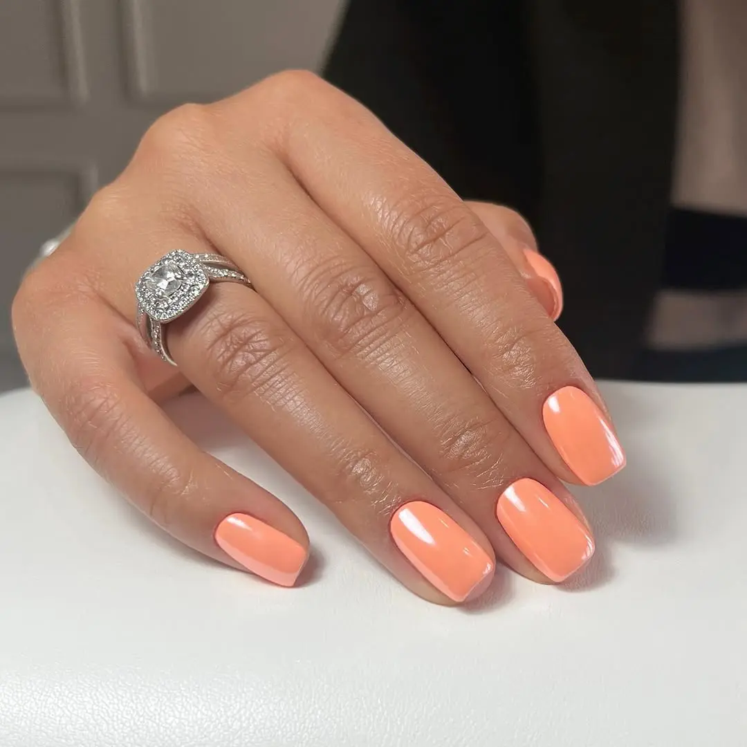 Vibrant orange nails for a summer glow.