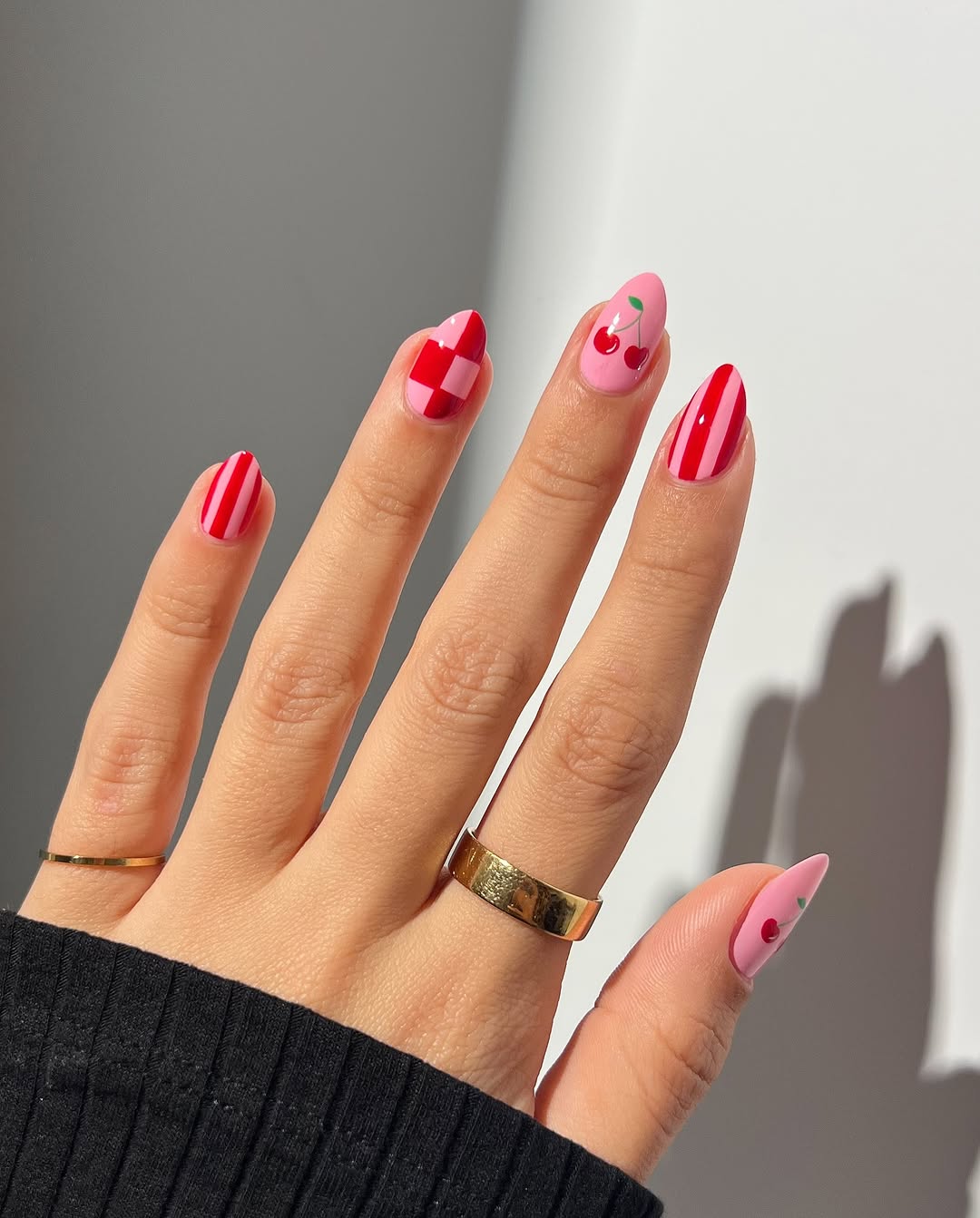 Chic pink nails with playful cherry accents