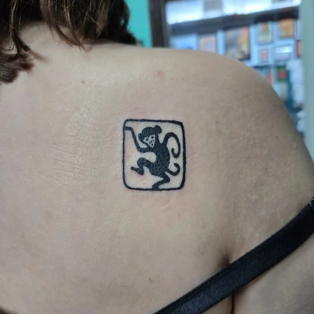 Unique playful monkey tattoo design on shoulder