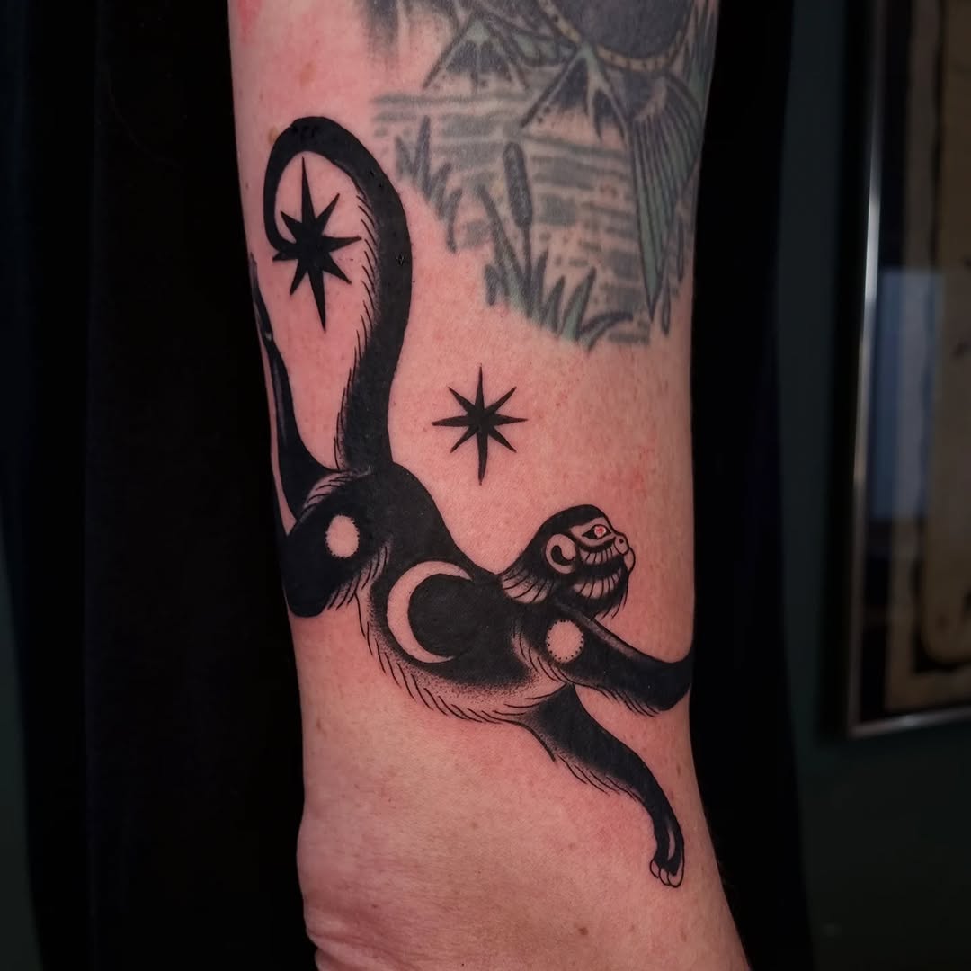 Playful monkey tattoo with celestial elements
