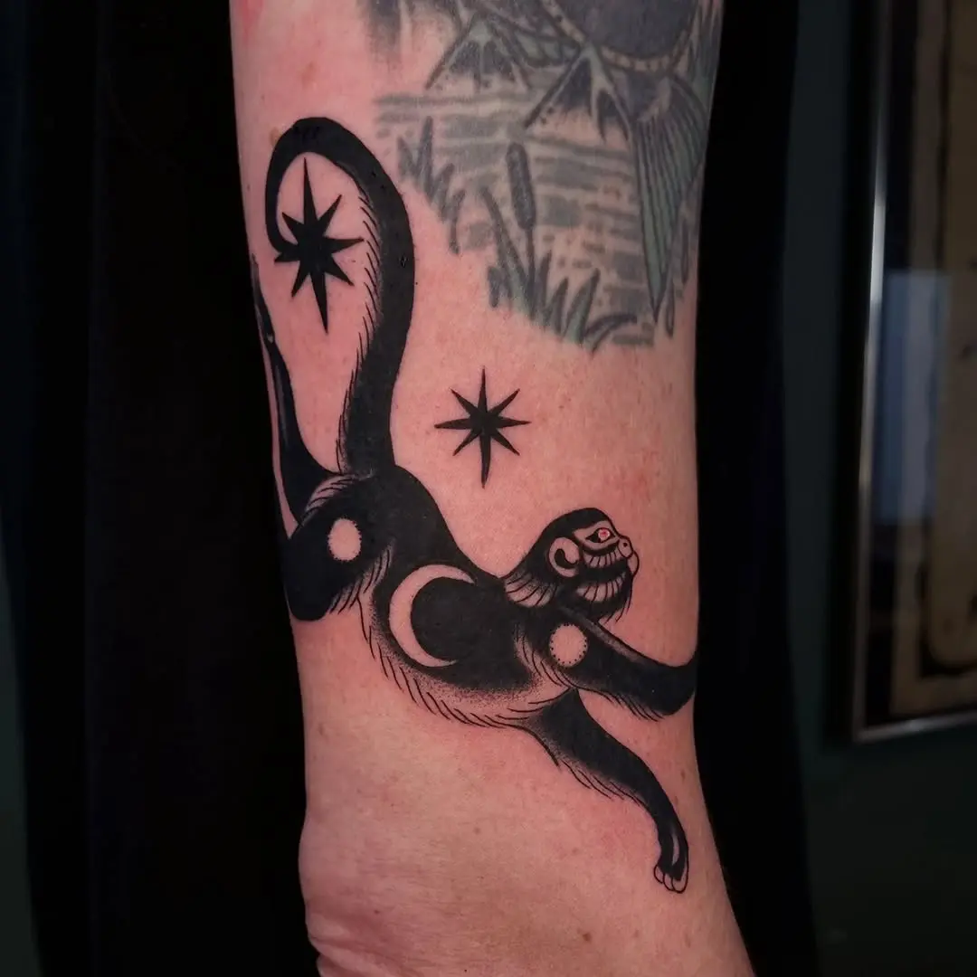 Playful monkey tattoo with celestial elements