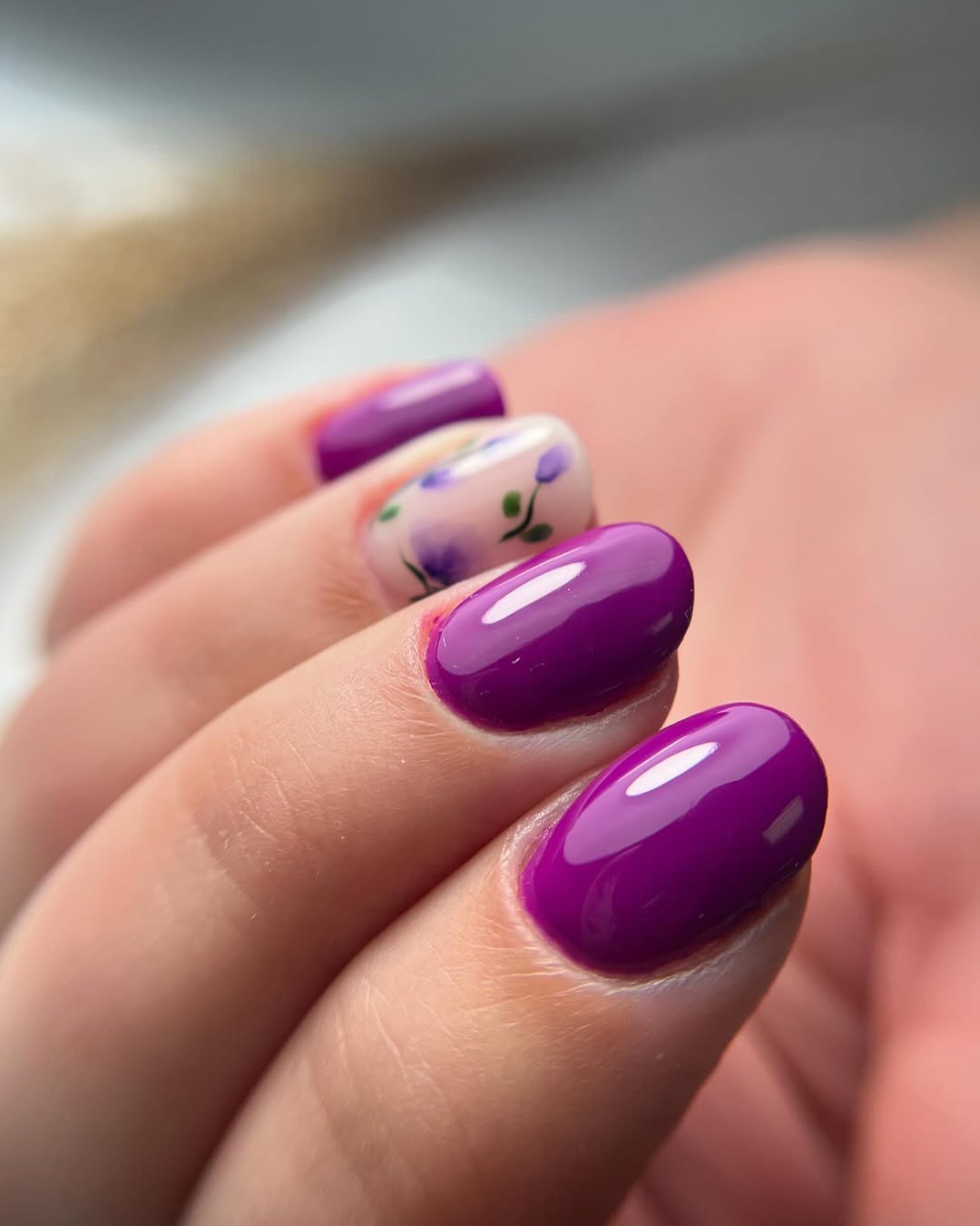 Vibrant purple nails with floral accent design