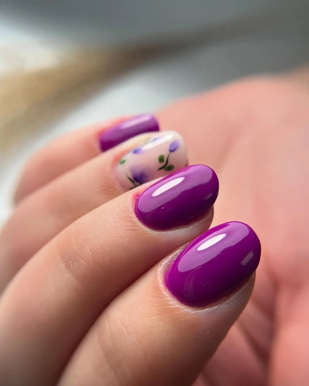Vibrant purple nails with floral accent design