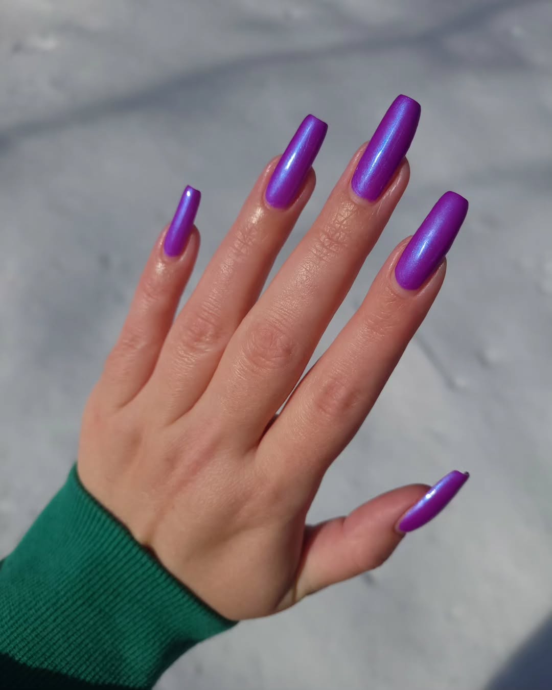 Vibrant purple nails shine under sunlight