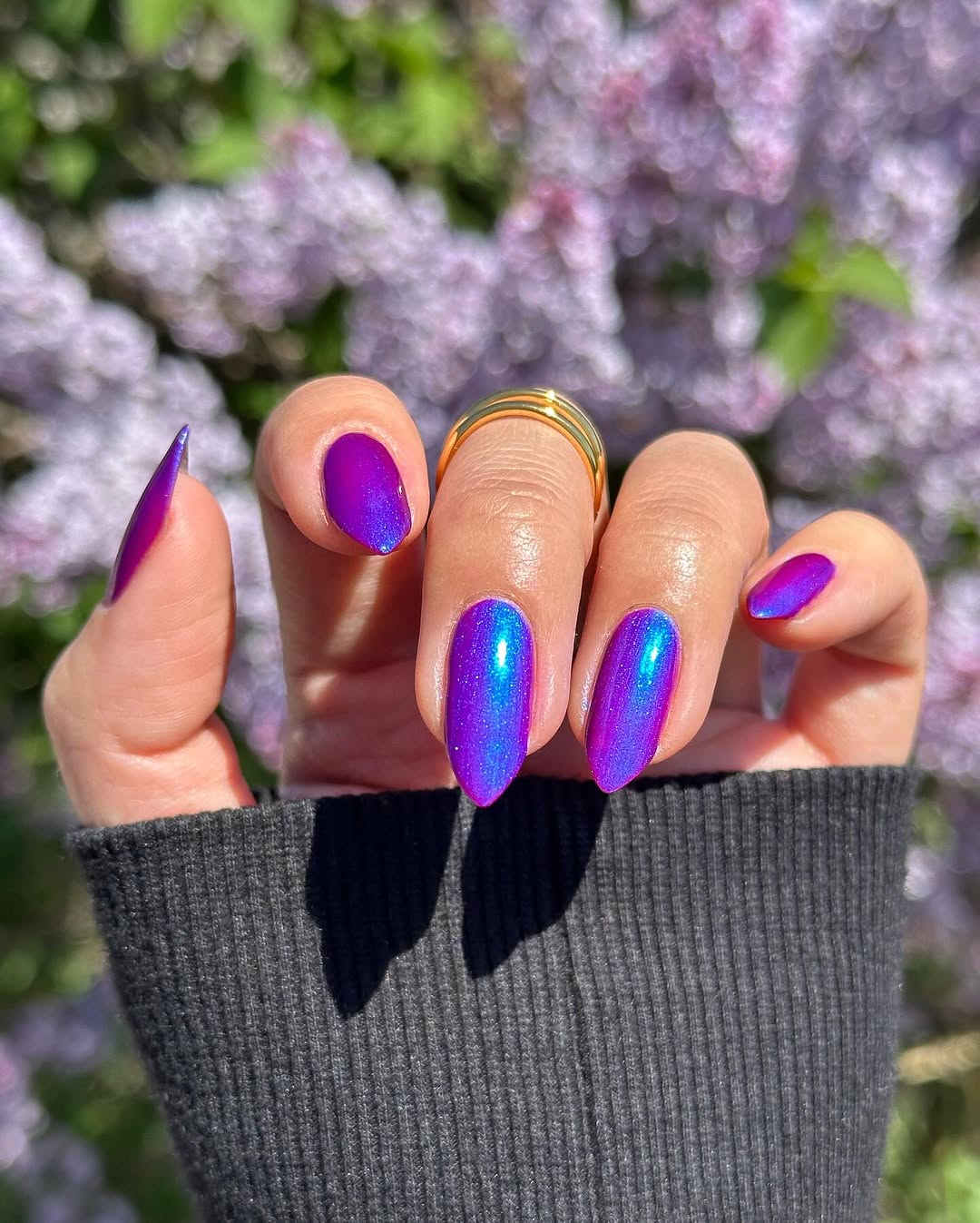 Vibrant purple shimmer nails under spring sunlight