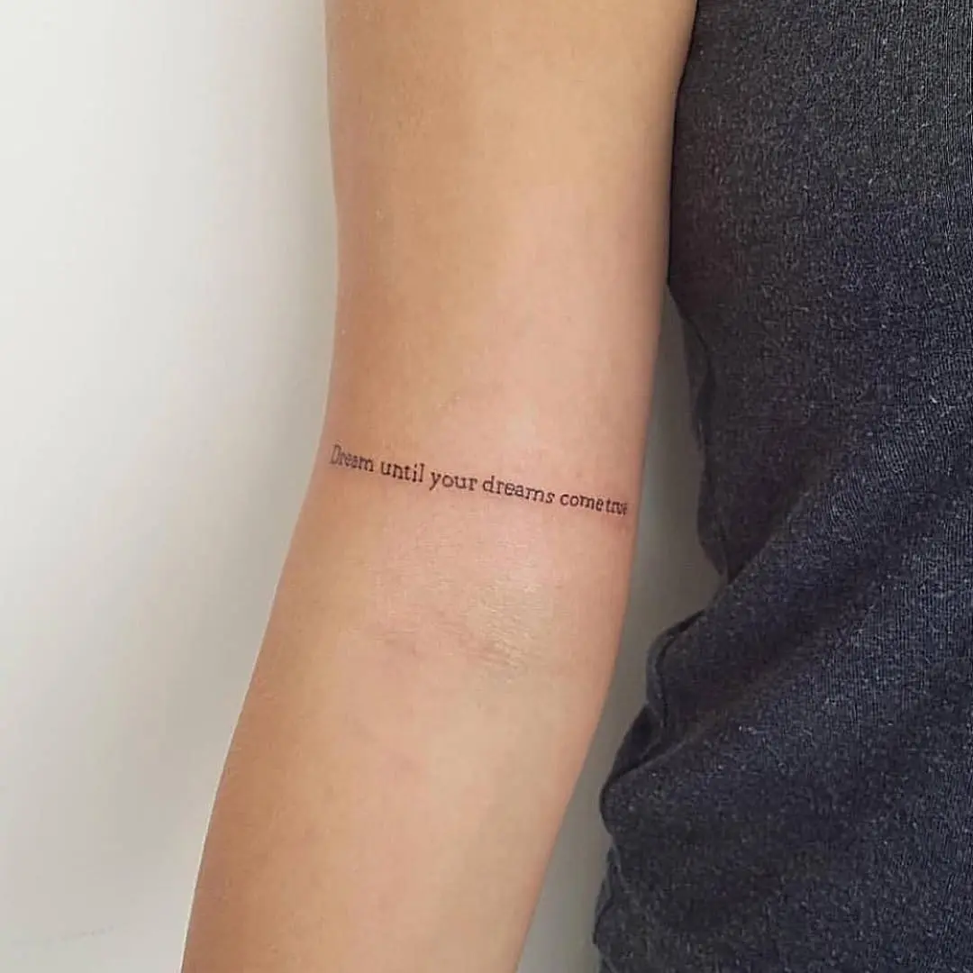 Inspirational quote tattoo on a forearm