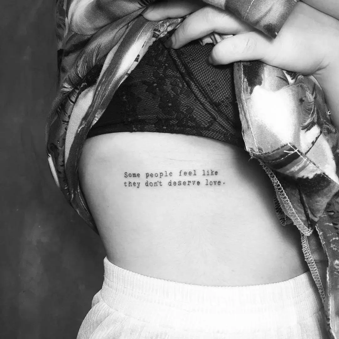 Elegant quote tattoo on rib cage.