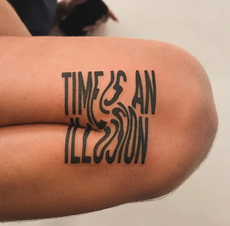 Stylized time illusion quote tattoo on knee