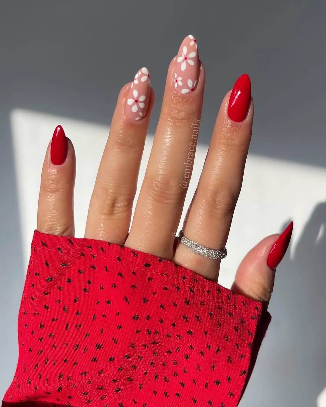 Chic red nails with floral accents showcased