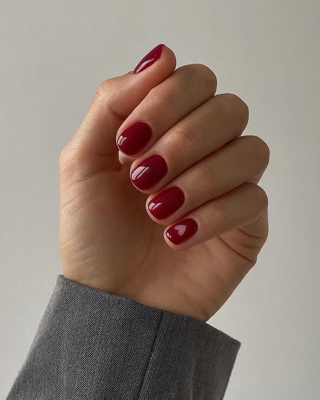 Elegant deep red nails in a chic pose