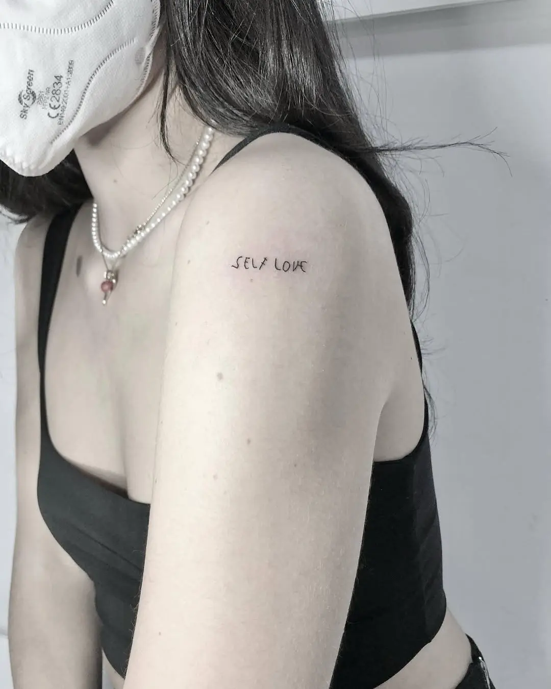 Minimalist self-love tattoo on the shoulder
