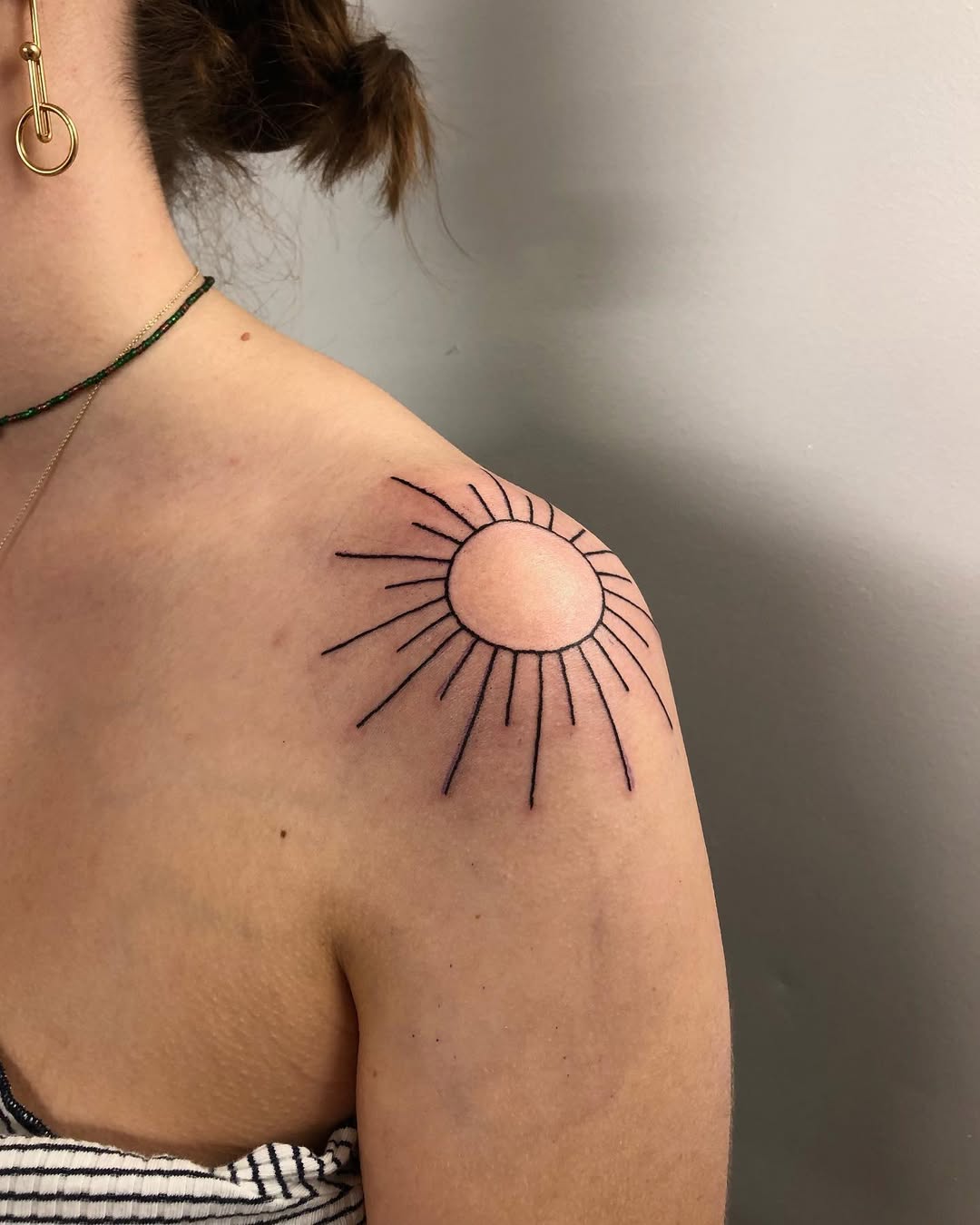 Elegant sun rays shoulder tattoo concept