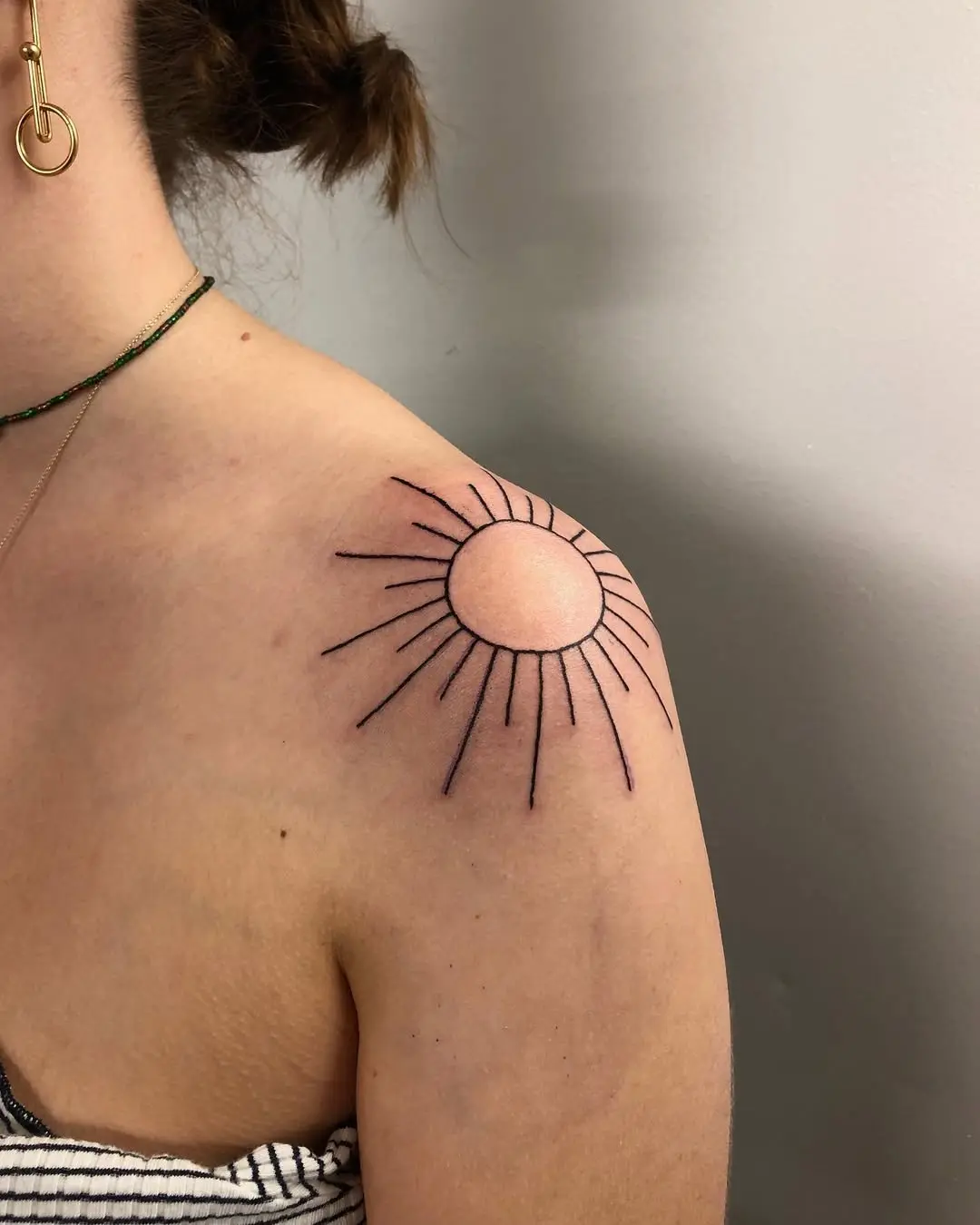 Elegant sun rays shoulder tattoo concept