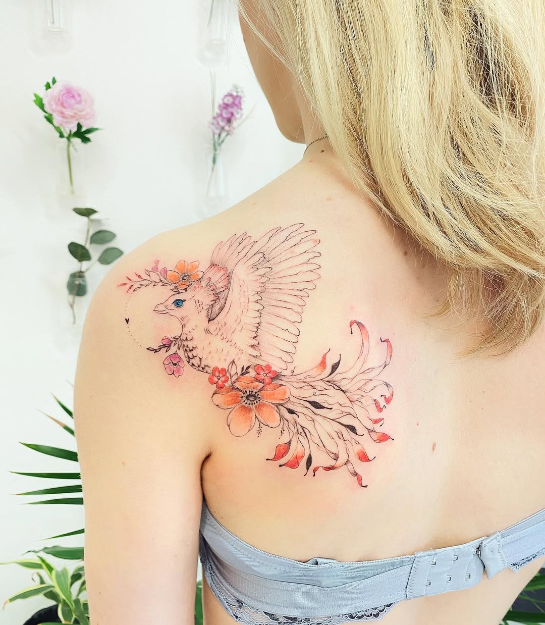 Whimsical bird with floral shoulder tattoo
