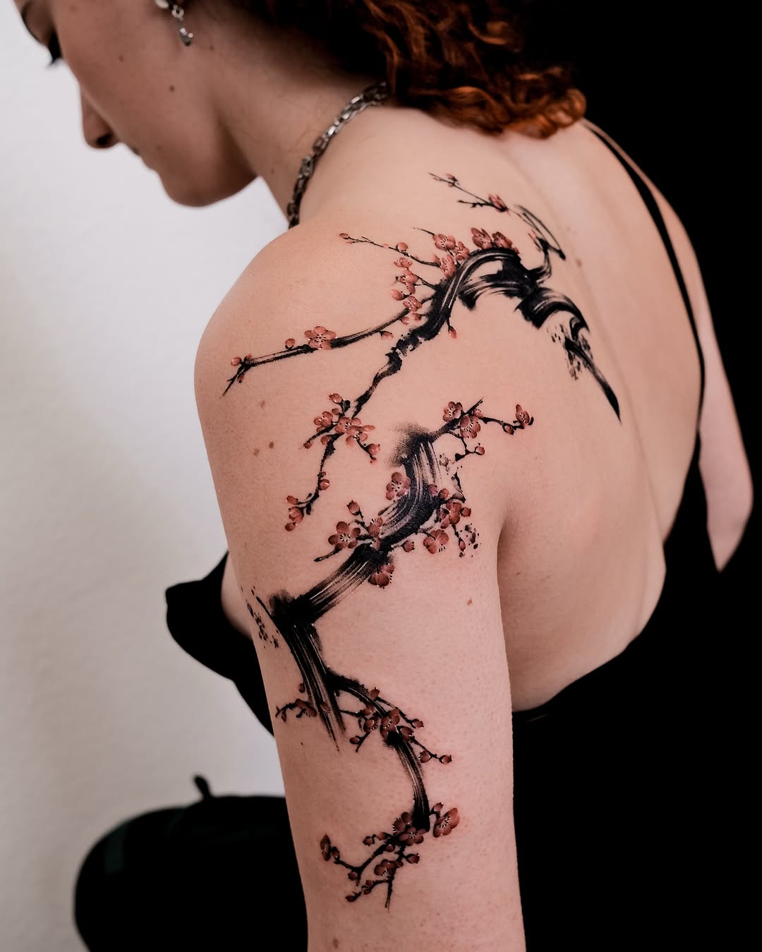 Elegant floral shoulder tattoo with branch design