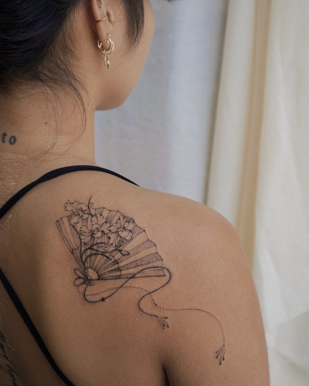 Elegant floral fan design on shoulder tattoo