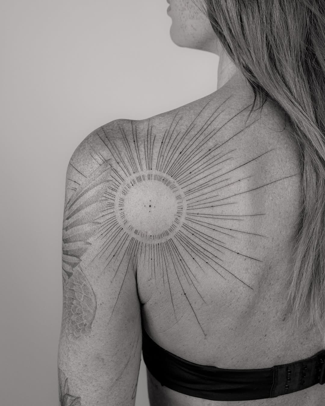 Elegant sunburst shoulder tattoo design