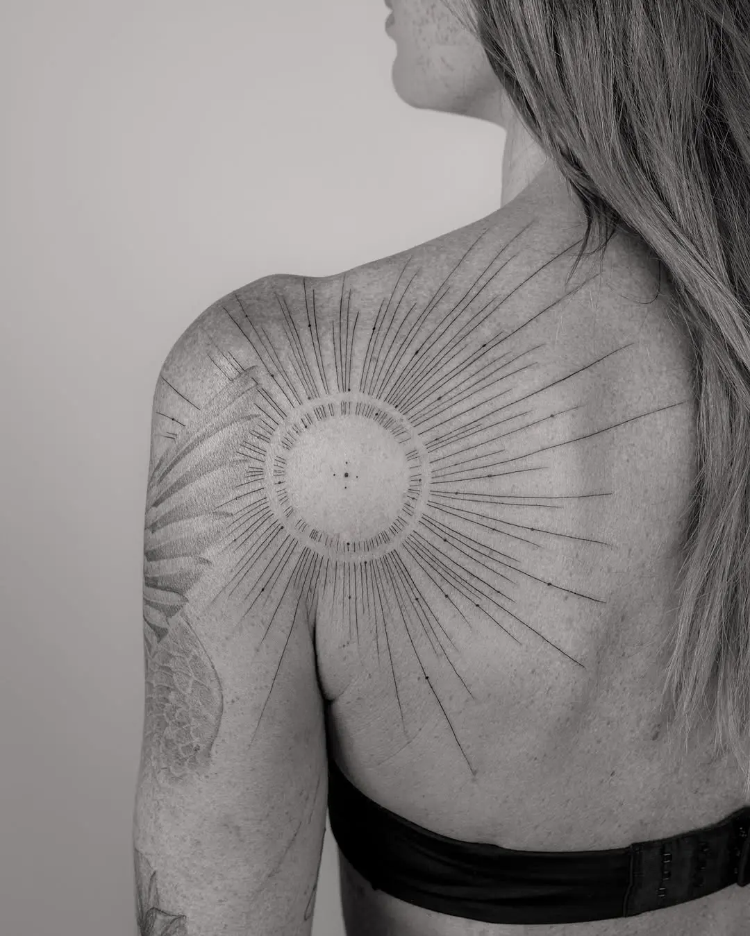 Elegant sunburst shoulder tattoo design