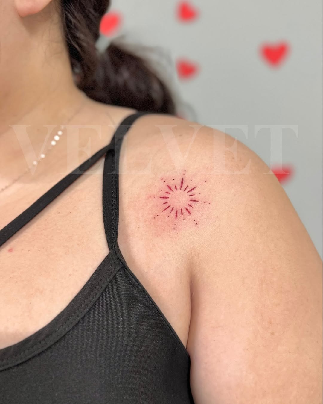 Minimalist sunburst tattoo on shoulder