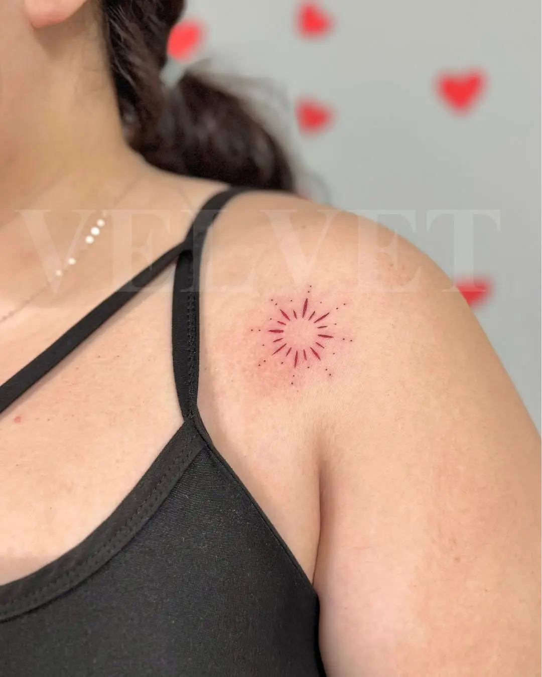 Minimalist sunburst tattoo on shoulder