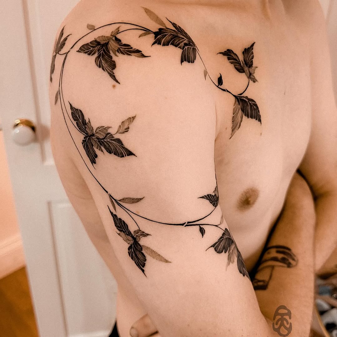 Elegant vine tattoo wrapping around shoulder