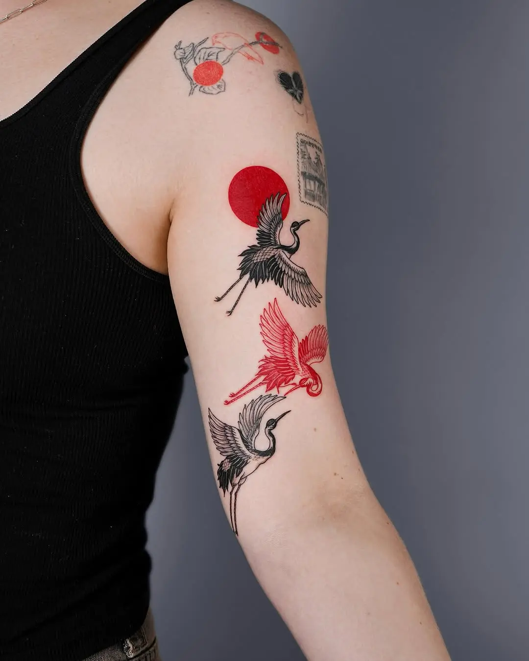Stylish shoulder tattoos featuring cranes and color