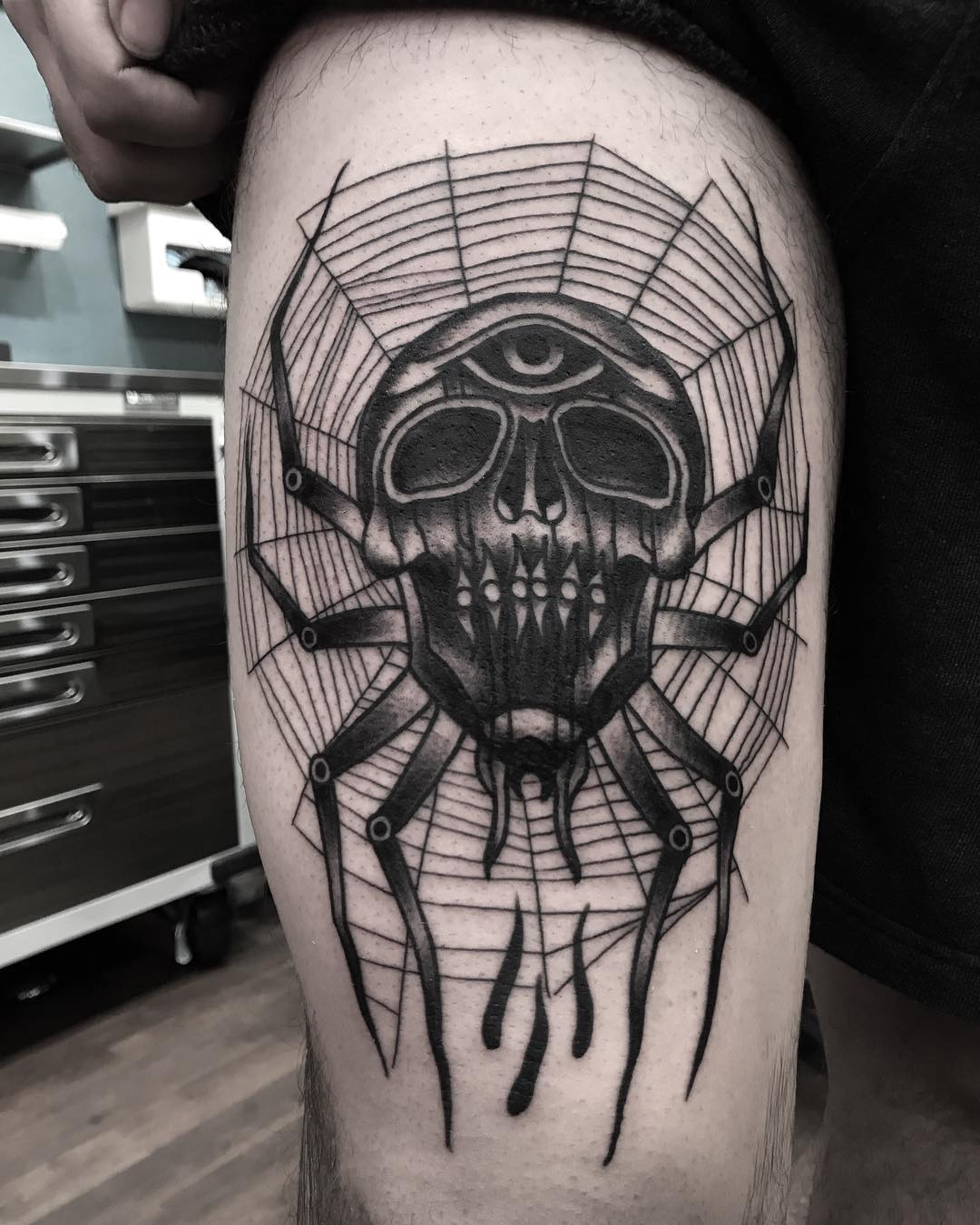 Intricate skull and spider web thigh tattoo