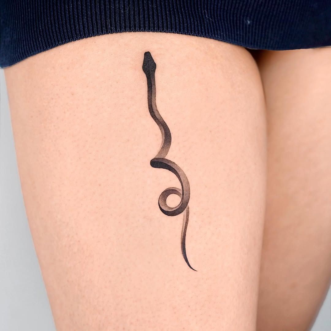 Sleek Black Snake Tattoo on Thigh