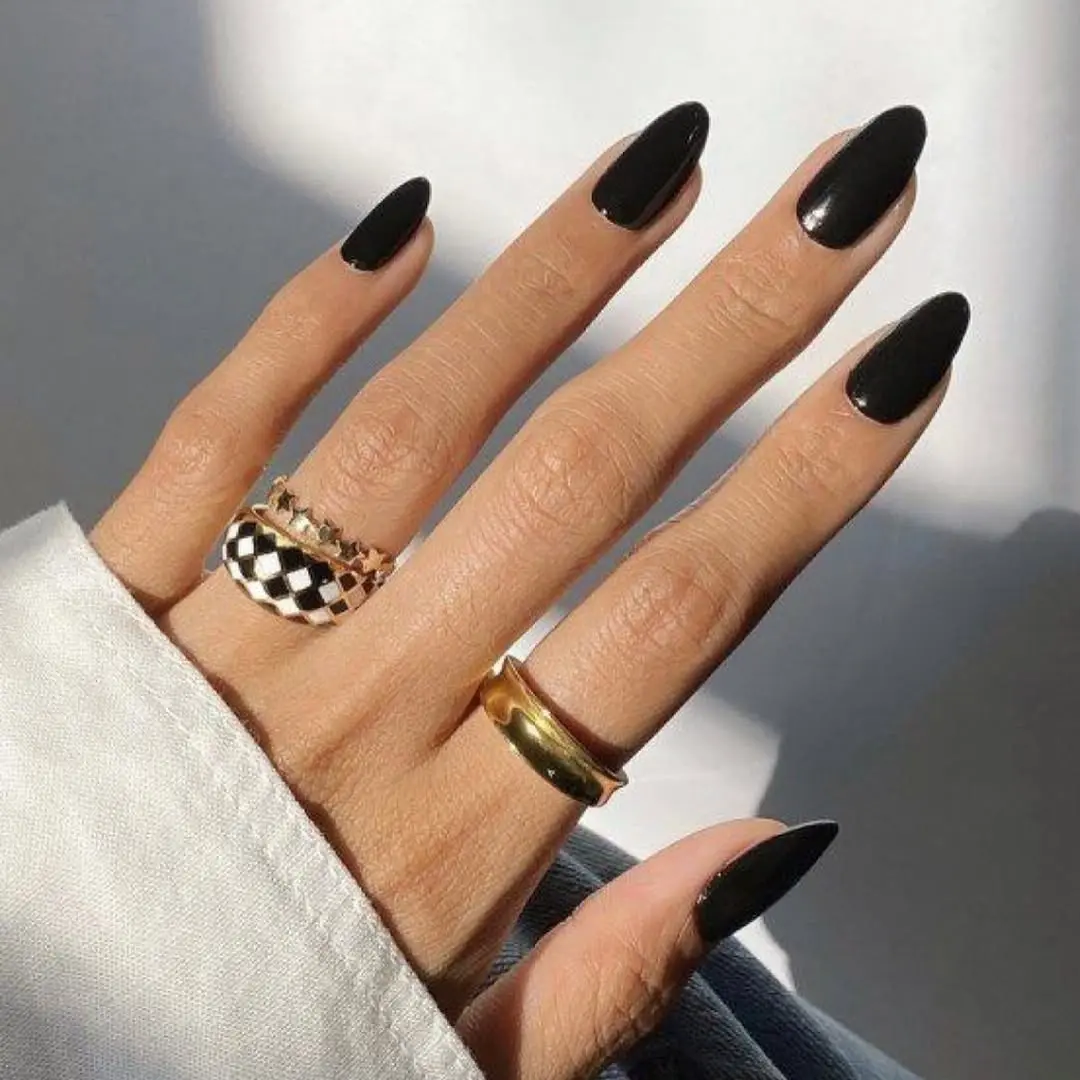 Chic black nails adorned with bold rings