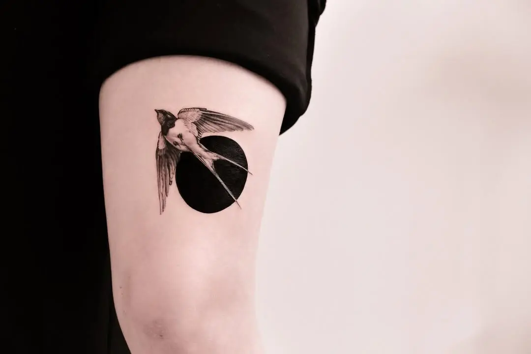 Stunning swallow tattoo against a dark backdrop