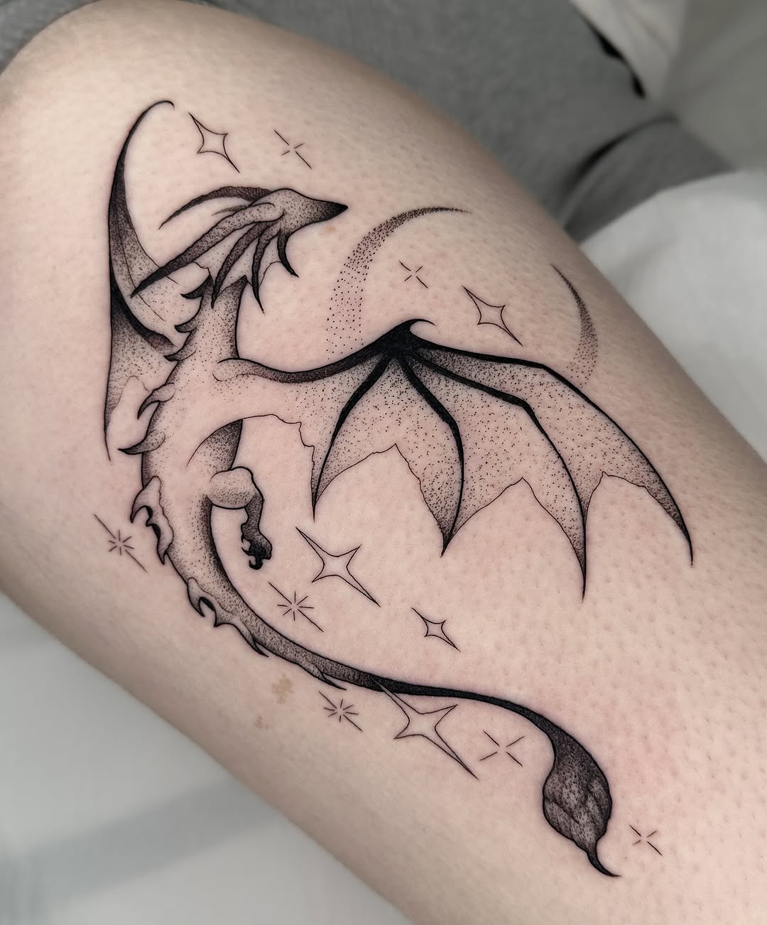 Elegant dragon tattoo soaring with celestial elements