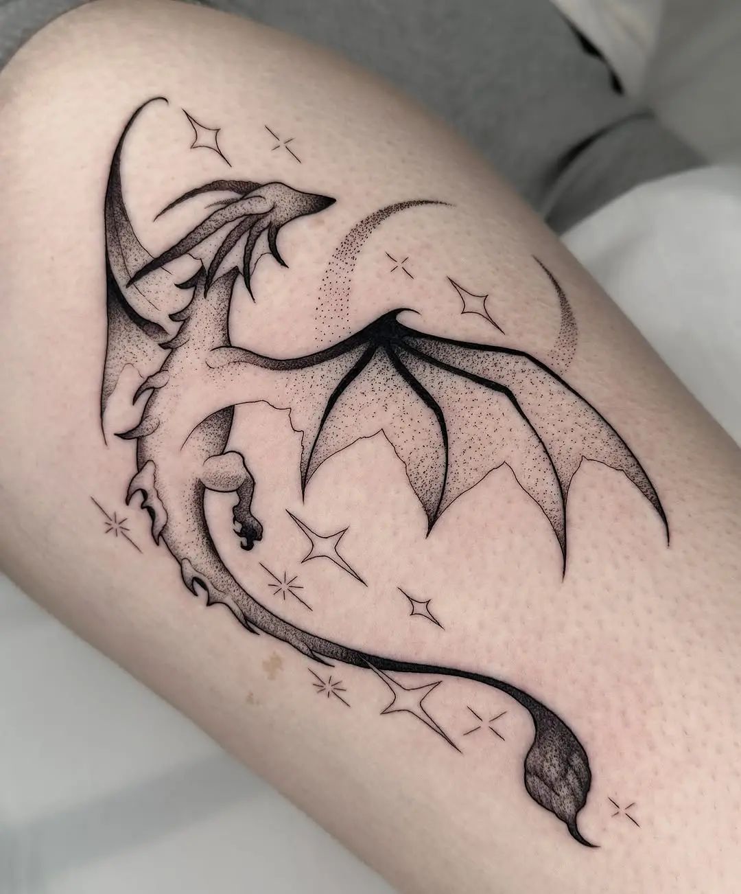 Elegant dragon tattoo soaring with celestial elements