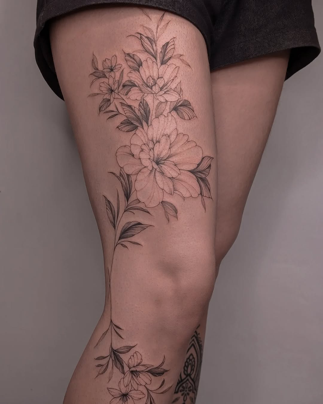 Elegant floral thigh tattoo showcasing delicate details