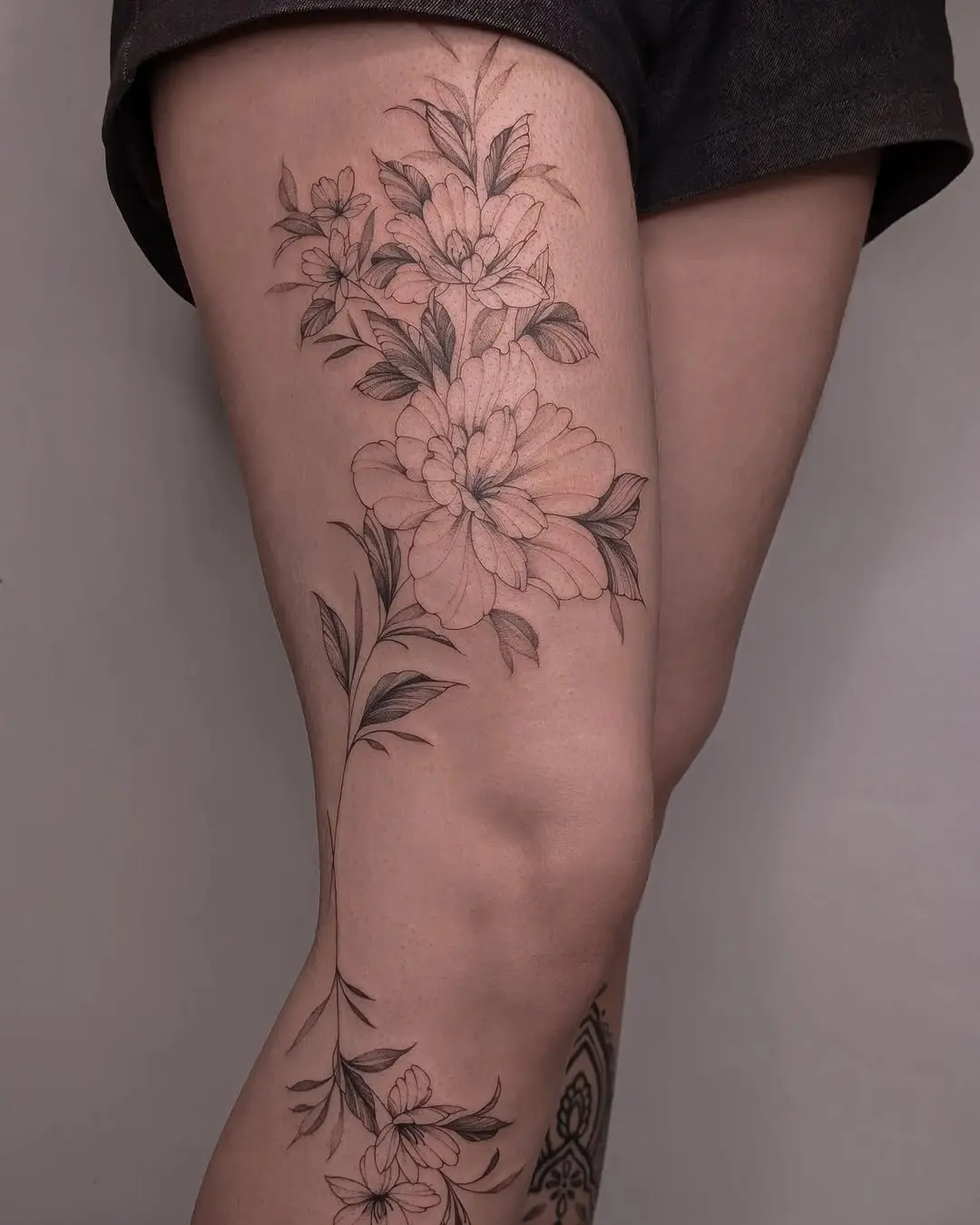 Elegant floral thigh tattoo showcasing delicate details