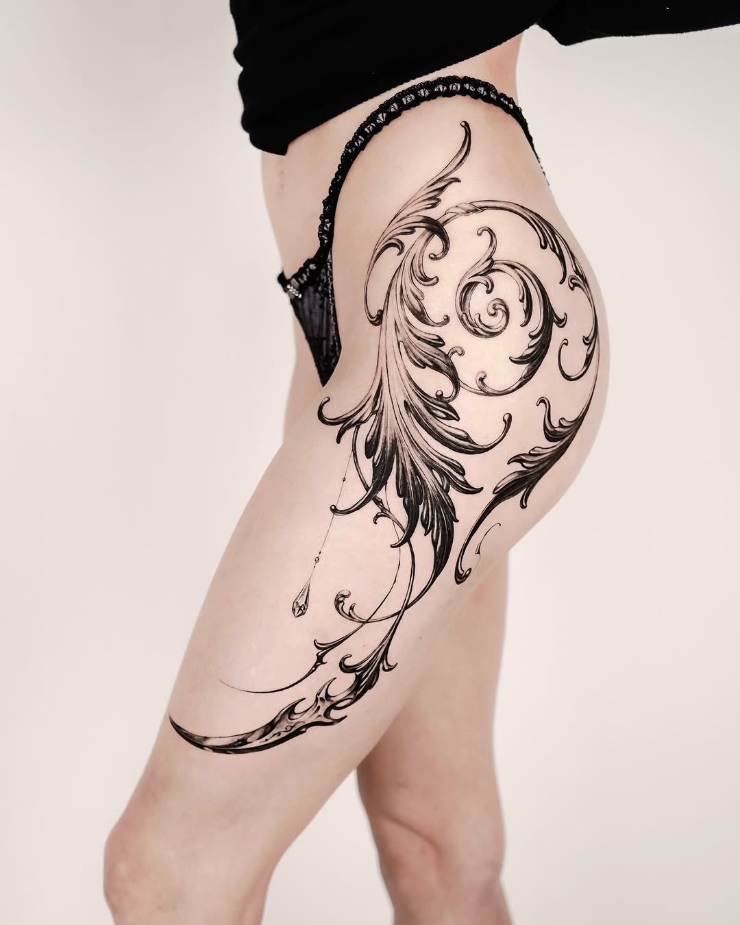 Elegant Flourish Design on Thigh Tattoo