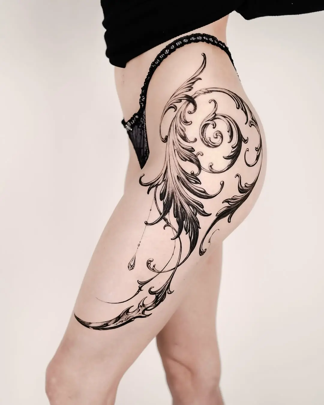 Elegant Flourish Design on Thigh Tattoo