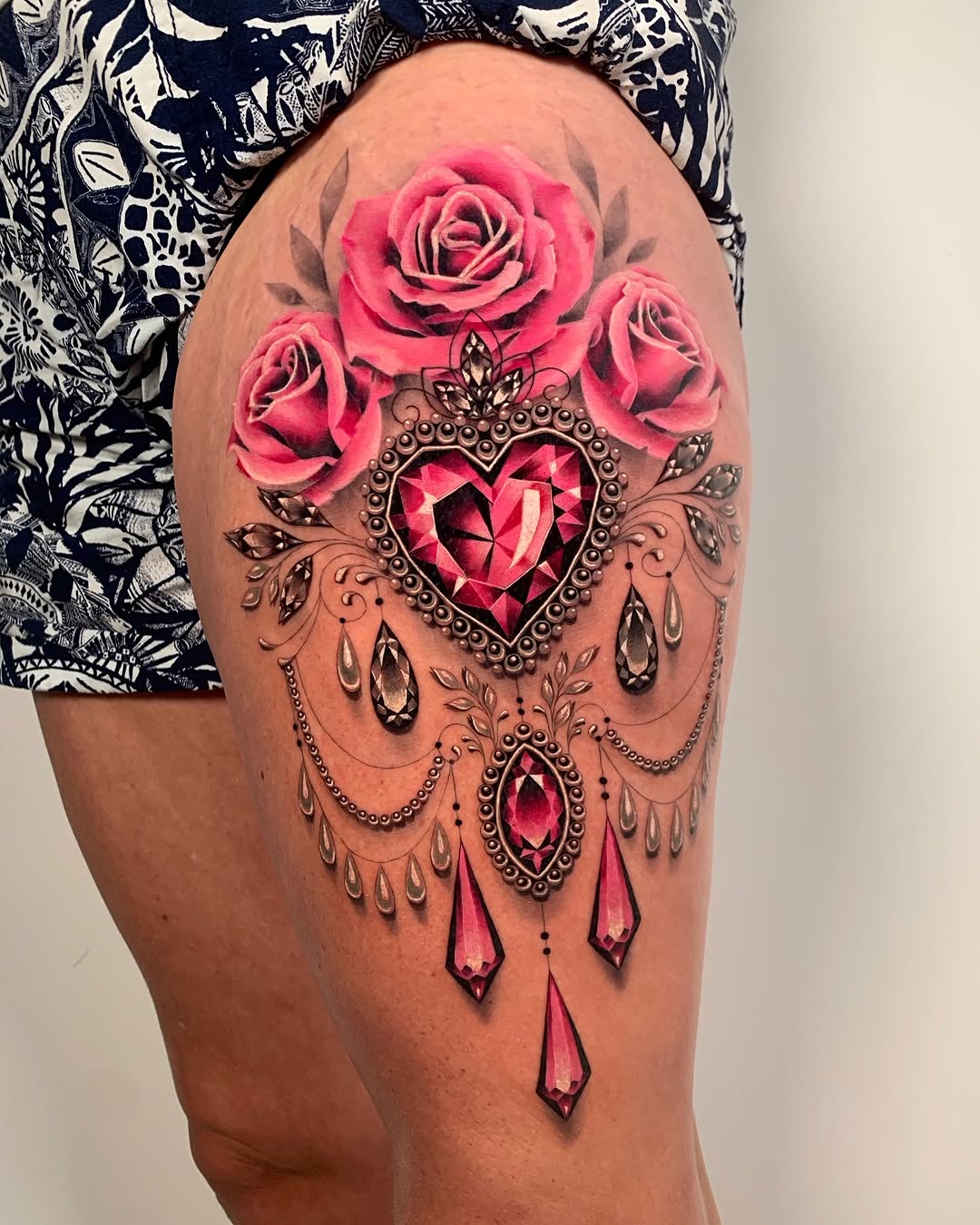 Elegant thigh tattoo with roses and jewels