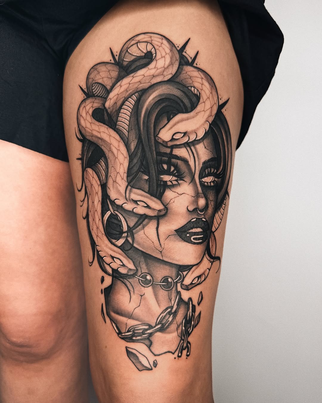 Stunning thigh tattoo featuring snakes and a portrait
