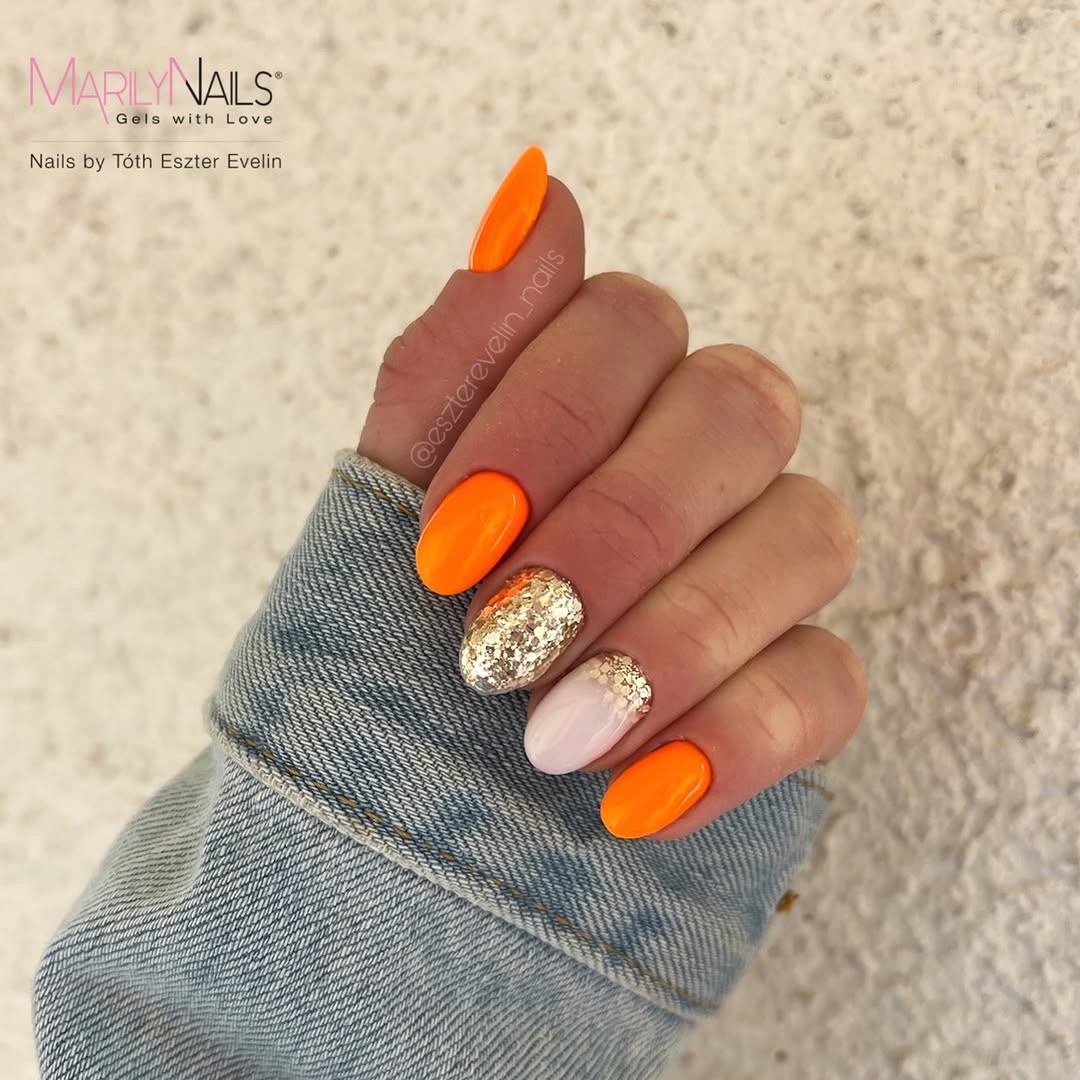 Bold orange nails with glitter accents shine bright