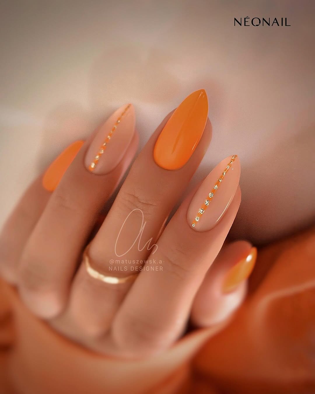 Stylish orange nails with elegant accents