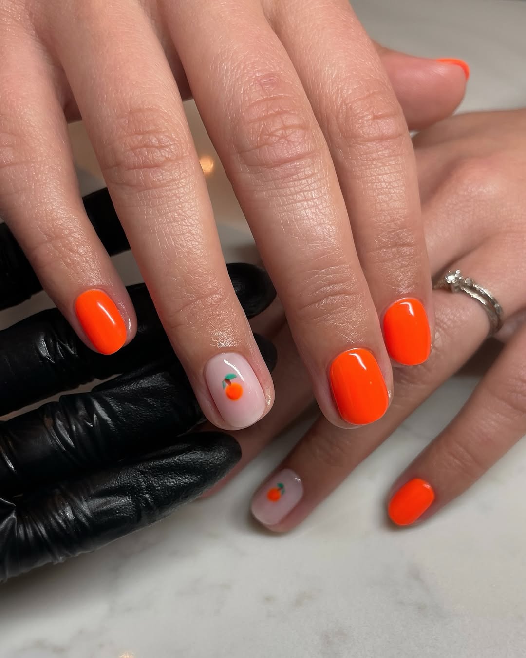 Bold orange nails with playful fruit design