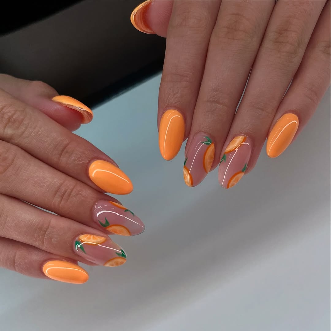 Bright orange nails with fruit accents