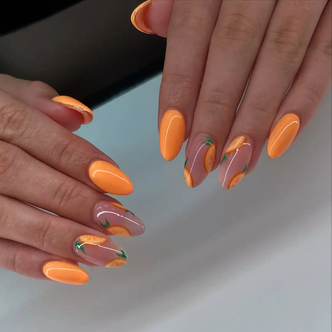 Bright orange nails with fruit accents