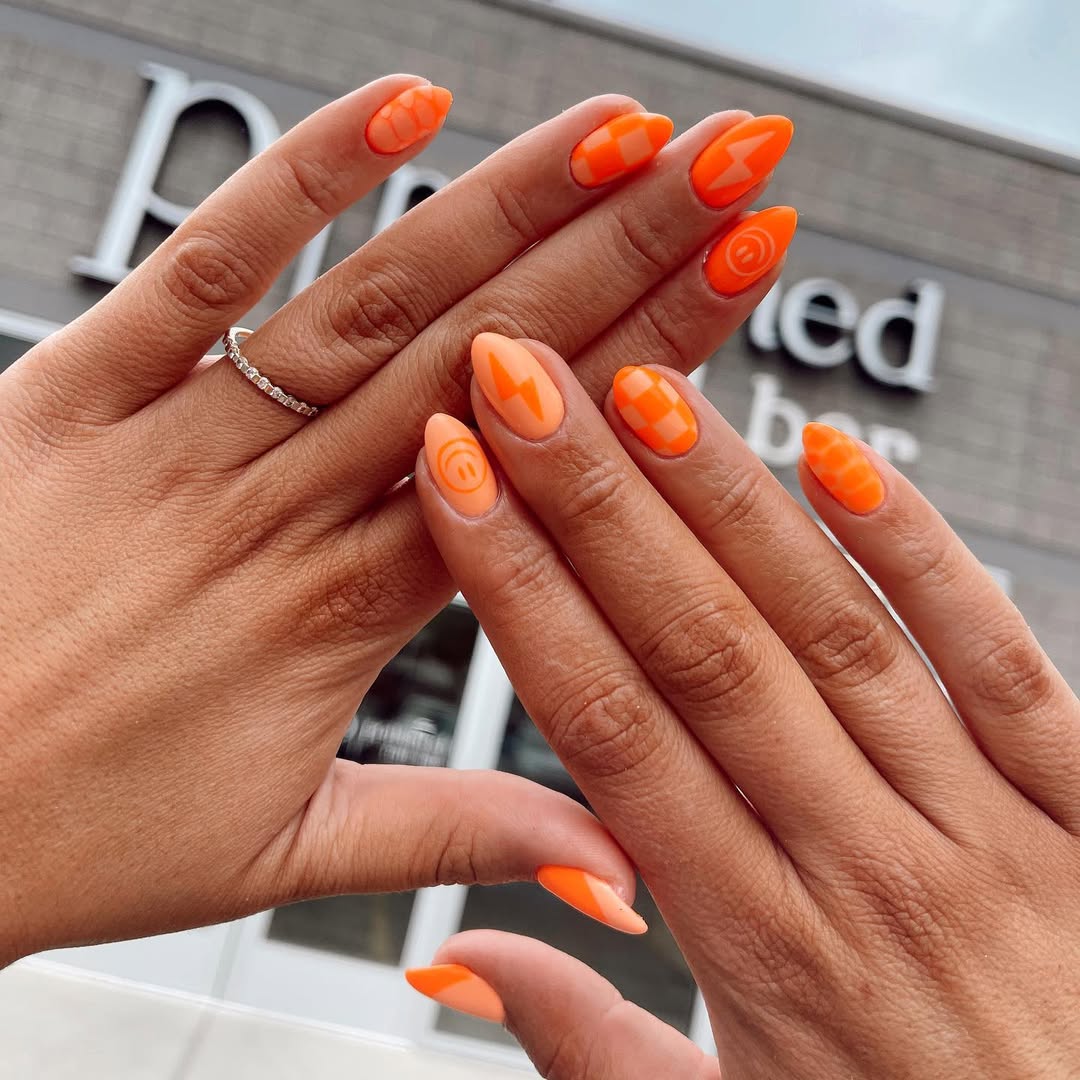 Geometric patterns on vibrant orange nails