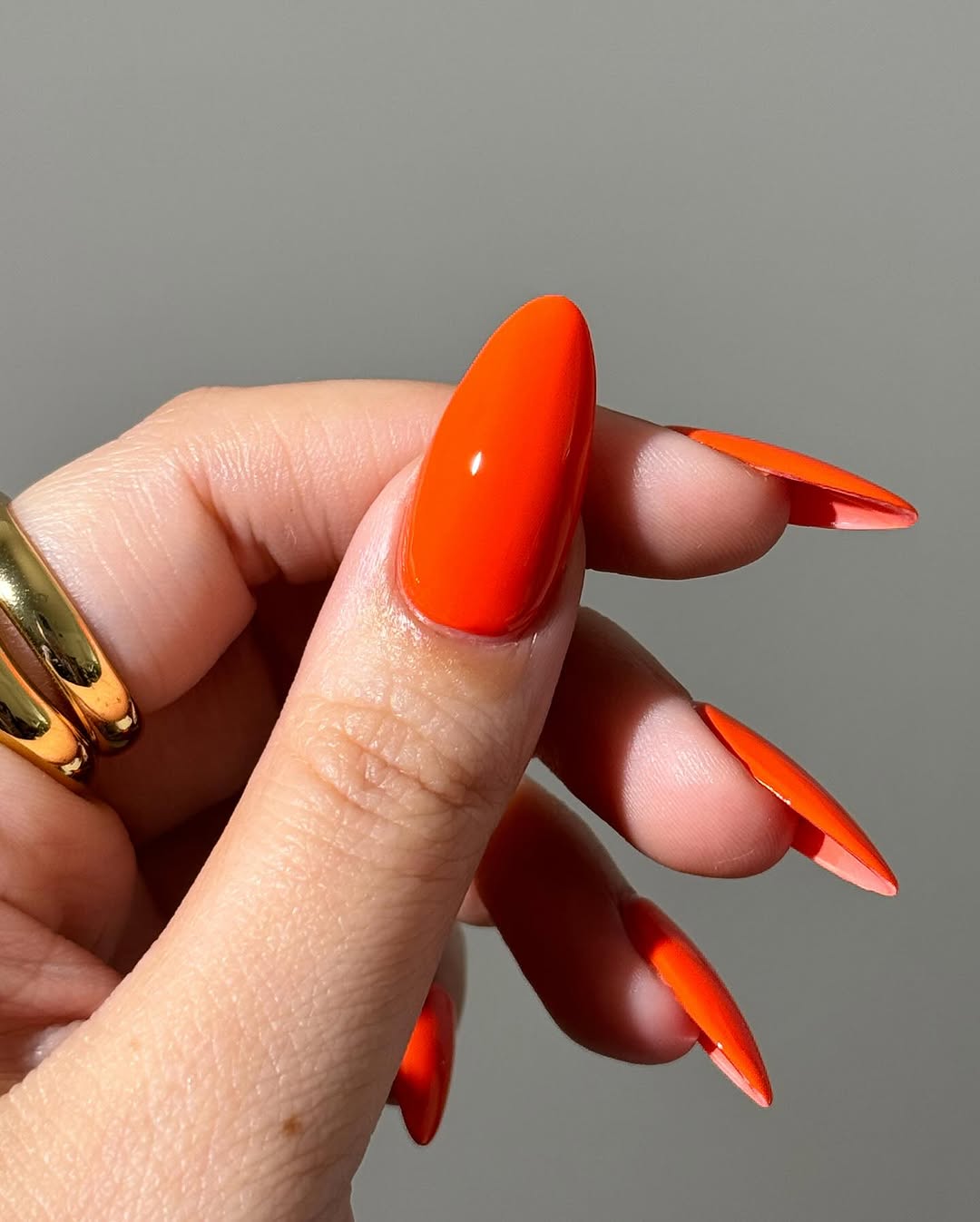 Bold and vibrant orange stiletto nail design