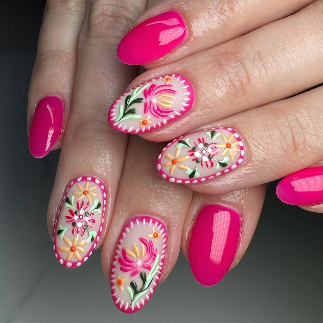 Vibrant floral patterns on pink nails
