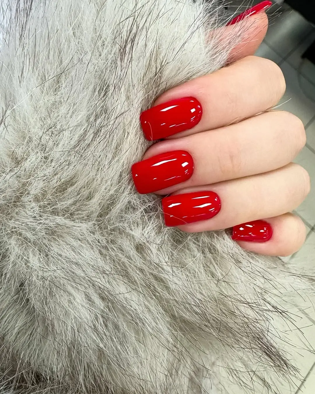 Bold red nails paired with luxurious faux fur